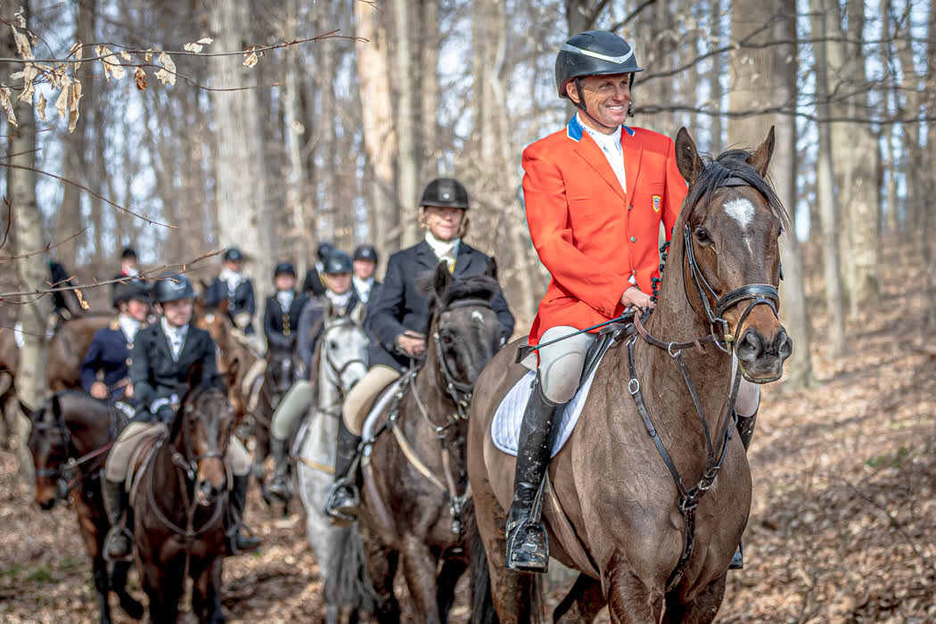 Boyd Martin in red coat leading group of hunt riders on horseback