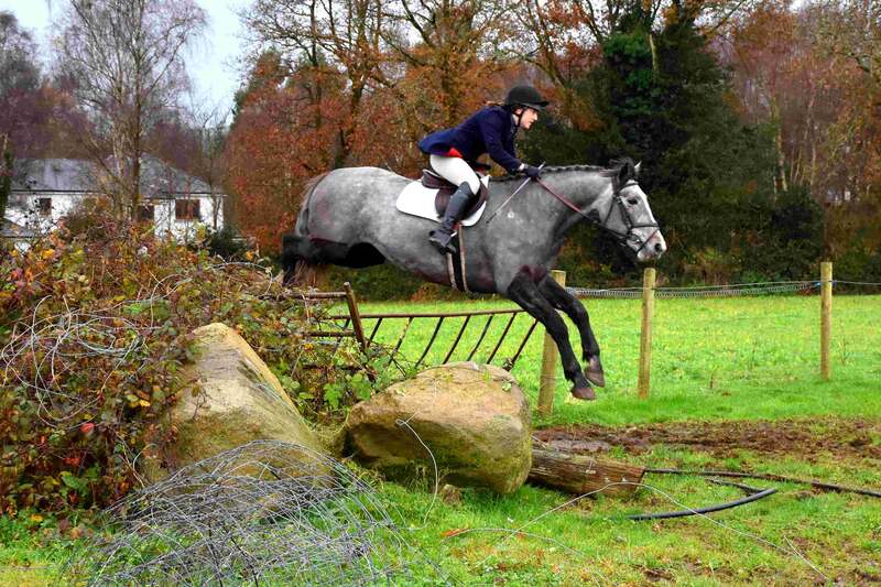 Hunt horse and rider in formal attire jumping in the country